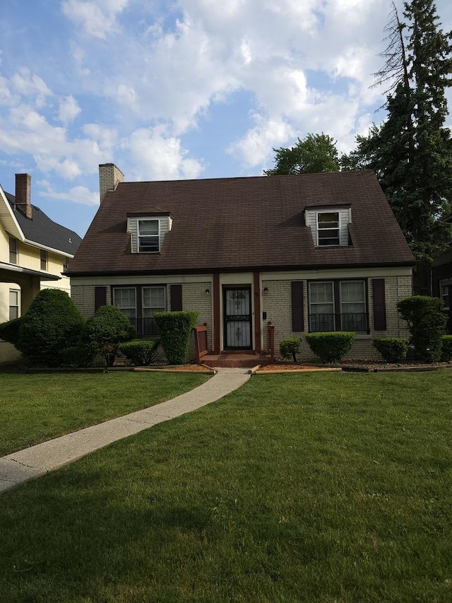 46 E 155th St, Harvey, IL 60426 - new england style home featuring a front lawn, brick siding, and a chimney