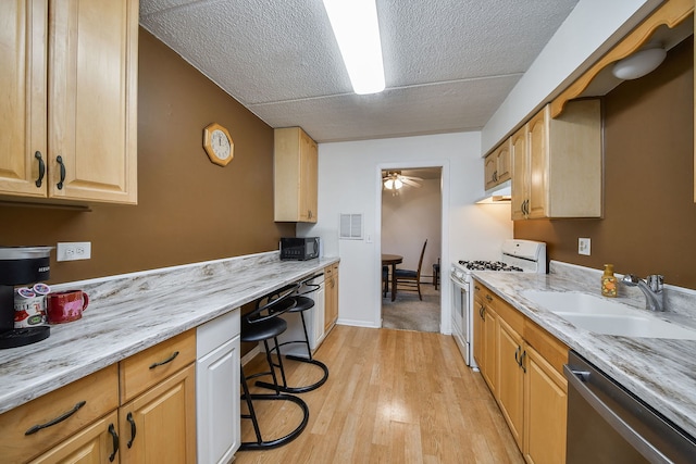 100 W Park Cir Unit 1E, Wheaton, IL 60187 - kitchen featuring white range with gas stovetop, a sink, stainless steel dishwasher, under cabinet range hood, and a textured ceiling