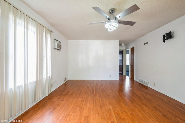 14841 Langley Ave, Dolton, IL 60419 - spare room with a ceiling fan, light wood-type flooring, a textured ceiling, and an AC wall unit