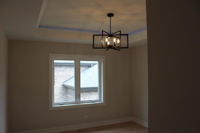 5660 W 83rd Pl, Burbank, IL 60459 - empty room featuring a chandelier, baseboards, light wood-style floors, and a raised ceiling