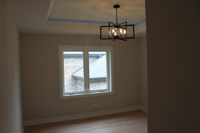 5660 W 83rd Pl, Burbank, IL 60459 - unfurnished room with a chandelier, light wood finished floors, baseboards, and a raised ceiling