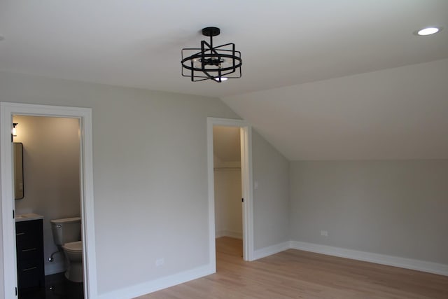 5660 W 83rd Pl, Burbank, IL 60459 - unfurnished bedroom featuring light wood-style flooring, a spacious closet, baseboards, lofted ceiling, and a chandelier