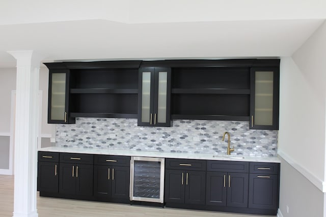 5660 W 83rd Pl, Burbank, IL 60459 - bar with wine cooler, a sink, ornate columns, and backsplash