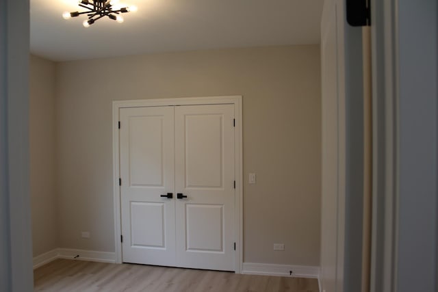 5660 W 83rd Pl, Burbank, IL 60459 - unfurnished bedroom with light wood-style flooring, a chandelier, baseboards, and a closet