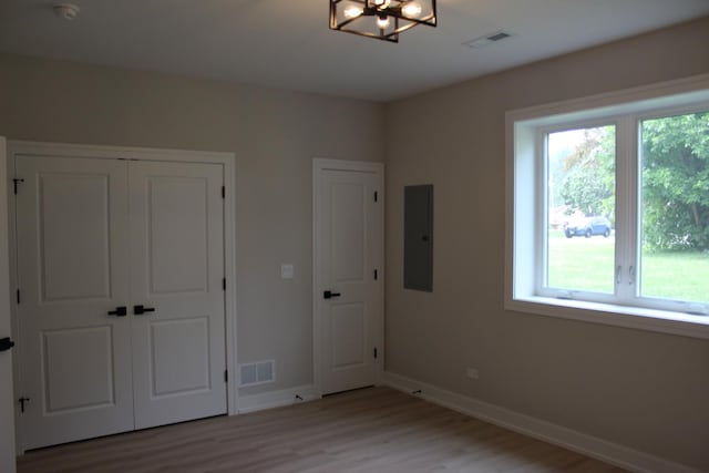 5660 W 83rd Pl, Burbank, IL 60459 - unfurnished bedroom with light wood-style flooring, electric panel, baseboards, a chandelier, and a closet