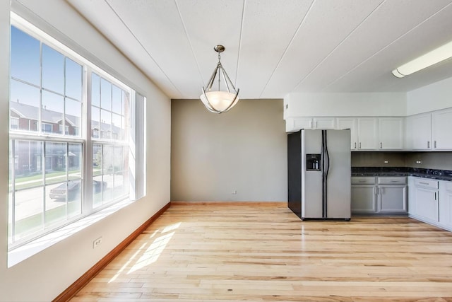 16671 Liberty Cir Unit 2N, Orland Park, IL 60467 - kitchen featuring stainless steel fridge with ice dispenser, light wood-style flooring, dark countertops, and pendant lighting