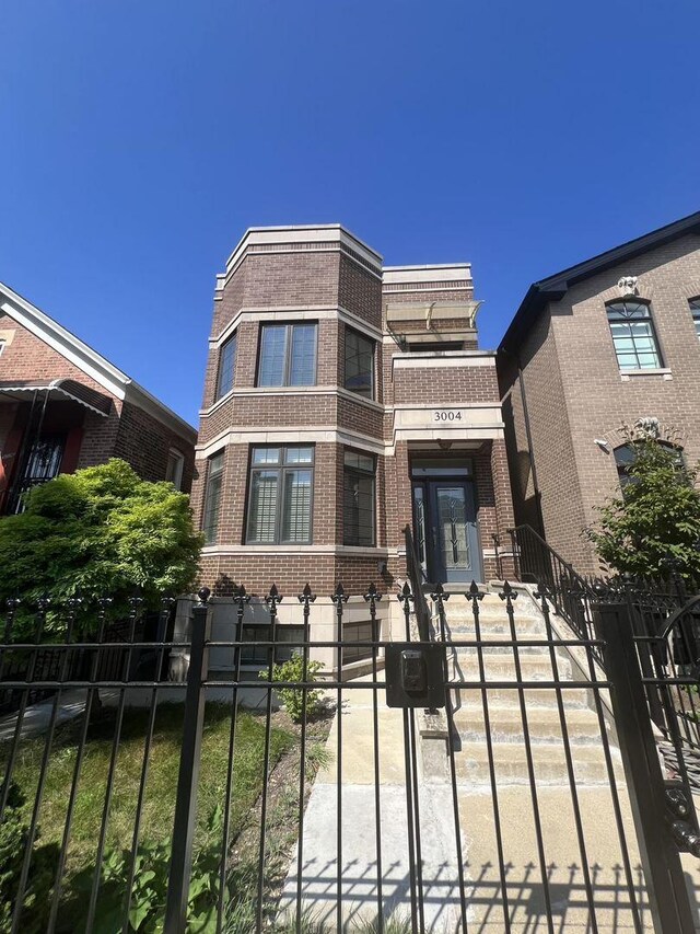 3004 S Canal St, Chicago, IL 60616 - view of front facade featuring brick siding, a fenced front yard, and a gate
