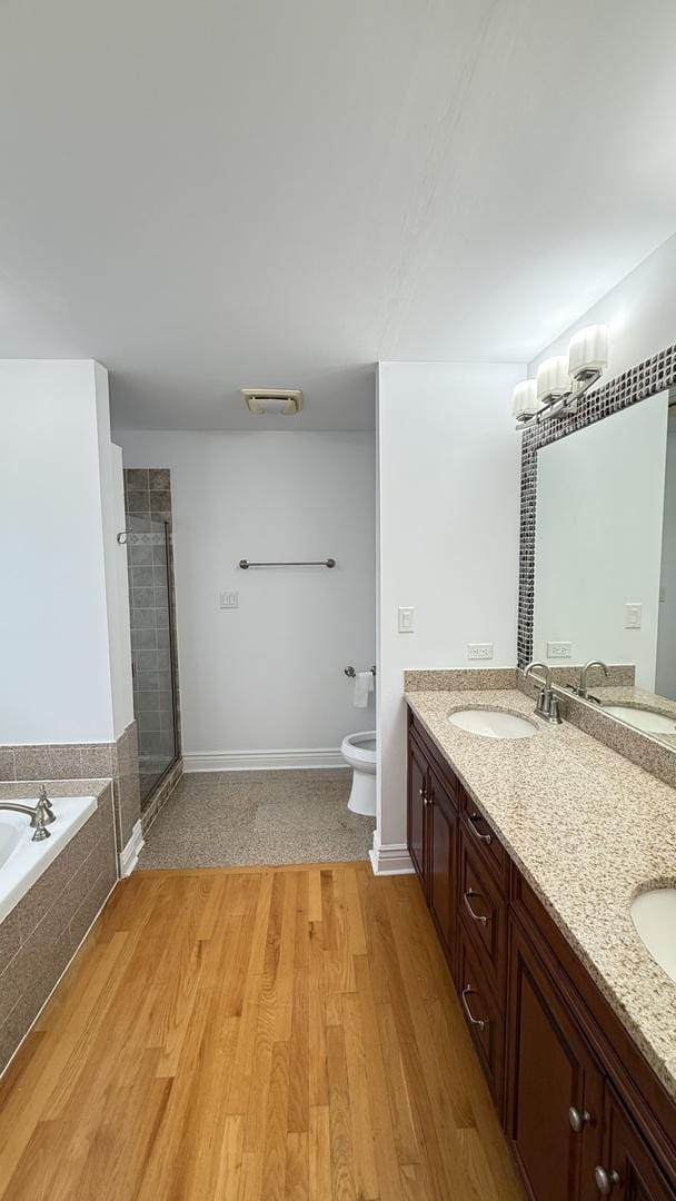 3004 S Canal St, Chicago, IL 60616 - bathroom featuring a bath, double vanity, a stall shower, toilet, and wood finished floors