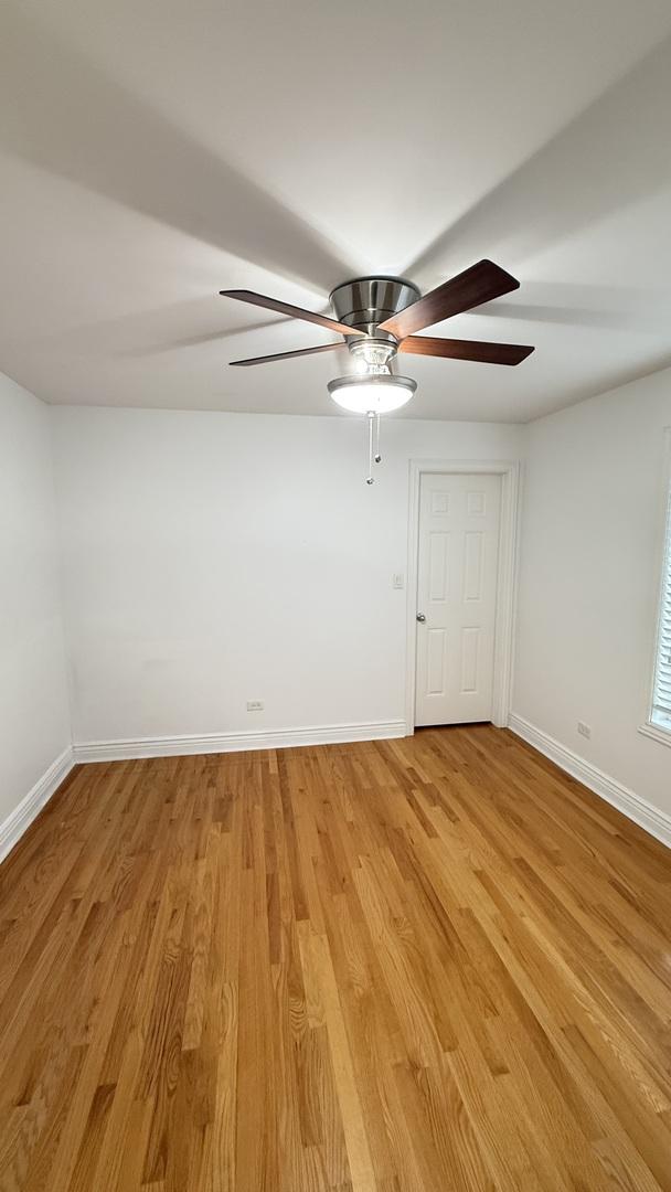 3004 S Canal St, Chicago, IL 60616 - spare room with baseboards, a ceiling fan, and light wood-type flooring