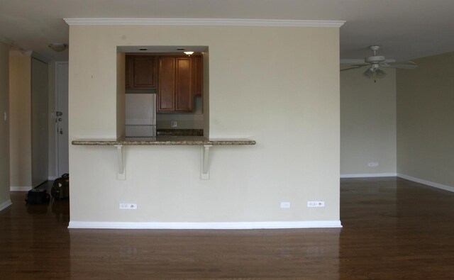 111 E Chestnut St Unit 15F, Chicago, IL 60611 - kitchen featuring fridge, dark wood finished floors, baseboards, crown molding, and a kitchen bar