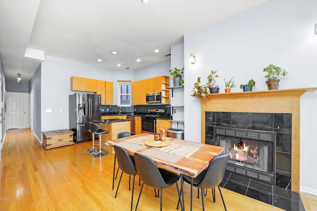 2744 W Haddon Ave Unit 2, Chicago, IL 60622 - dining area with light wood-type flooring, a tile fireplace, recessed lighting, and baseboards