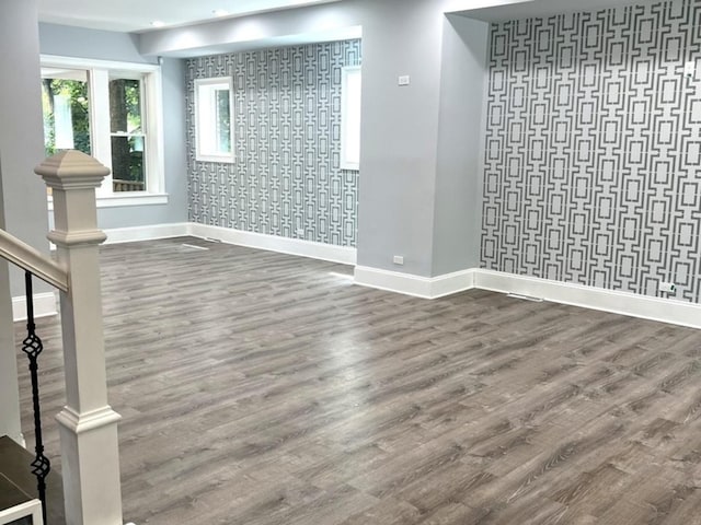 2627 E 74th Pl, Chicago, IL 60649 - empty room featuring baseboards, wood finished floors, an accent wall, and wallpapered walls