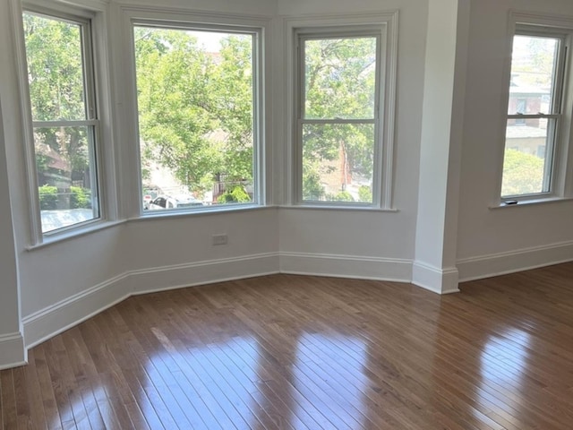 2627 E 74th Pl, Chicago, IL 60649 - empty room with dark wood-style flooring, baseboards, and healthy amount of natural light