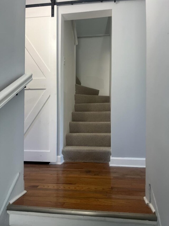 2627 E 74th Pl, Chicago, IL 60649 - stairs with wood finished floors, a barn door, and baseboards