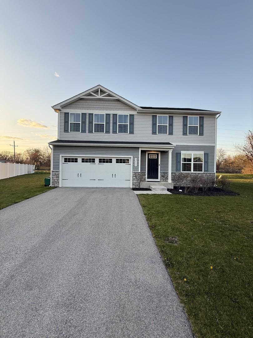 311 Fir Ln, Joliet, IL 60433 - view of front of home with stone siding, asphalt driveway, a garage, and a front yard
