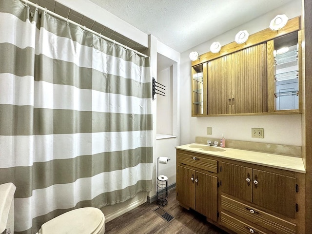 1204 W Reynolds St, Pontiac, IL 61764 - bathroom with toilet, wood finished floors, vanity, curtained shower, and a textured ceiling