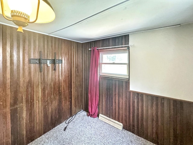 1204 W Reynolds St, Pontiac, IL 61764 - carpeted empty room with wood walls, baseboard heating, and a wainscoted wall