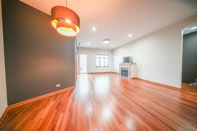 4770 N Manor Ave Unit 405, Chicago, IL 60625 - unfurnished living room featuring light wood-style flooring, baseboards, a fireplace, and recessed lighting