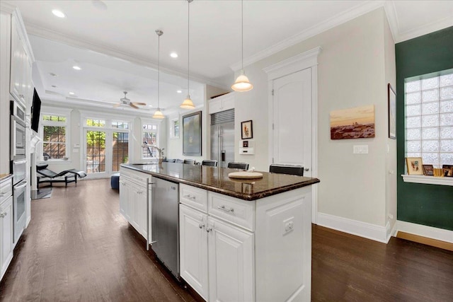 1332 W Wellington Ave, Chicago, IL 60657 - kitchen with appliances with stainless steel finishes, dark wood-style floors, crown molding, a kitchen island with sink, and baseboards