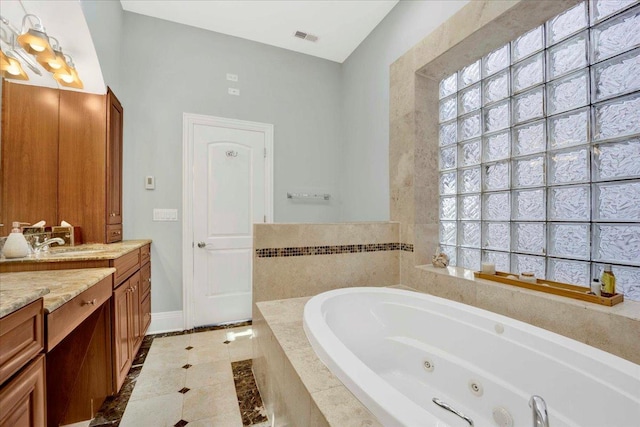 1332 W Wellington Ave, Chicago, IL 60657 - bathroom featuring a jetted tub, vanity, baseboards, and tile patterned floors