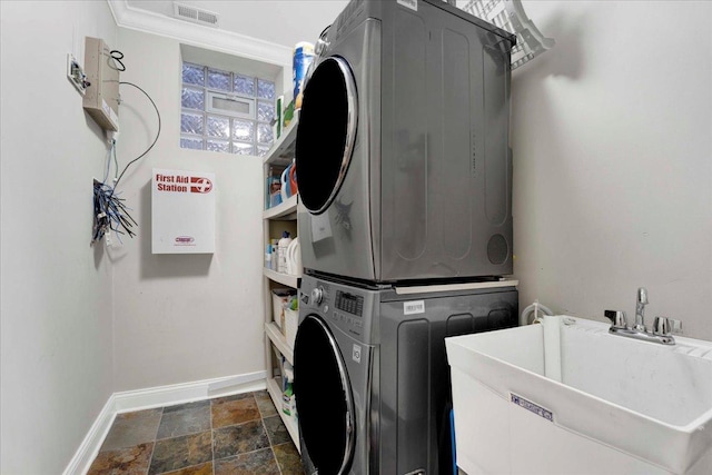 1332 W Wellington Ave, Chicago, IL 60657 - laundry area with stacked washer / drying machine, baseboards, and dark stone finish flooring