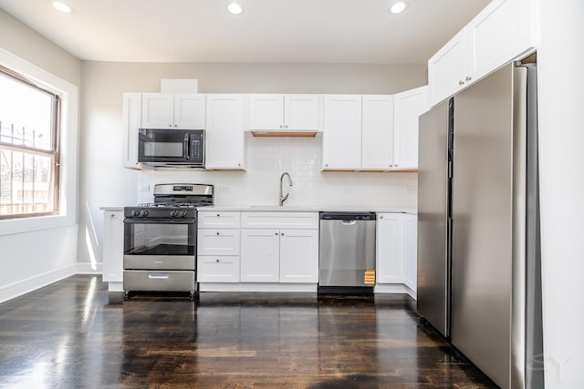 3651 W Grenshaw St, Chicago, IL 60624 - kitchen featuring appliances with stainless steel finishes, white cabinets, decorative backsplash, light countertops, and recessed lighting