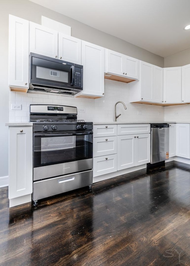 3651 W Grenshaw St, Chicago, IL 60624 - kitchen with appliances with stainless steel finishes, dark wood-style flooring, white cabinets, light countertops, and backsplash