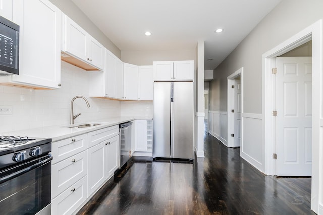 3651 W Grenshaw St, Chicago, IL 60624 - kitchen featuring appliances with stainless steel finishes, white cabinetry, light countertops, tasteful backsplash, and dark wood-style floors