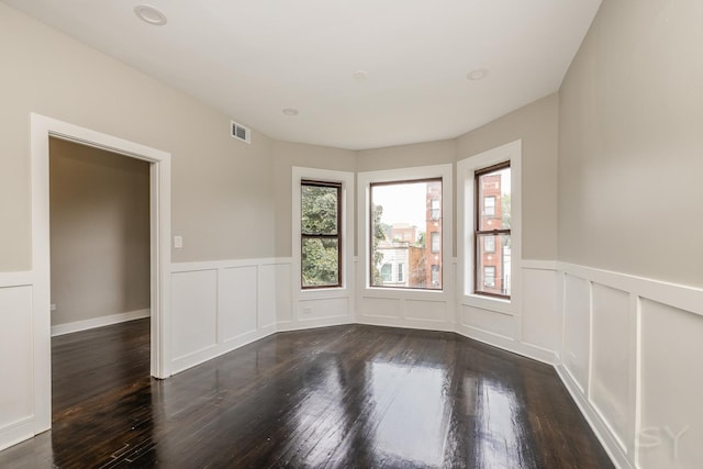 3651 W Grenshaw St, Chicago, IL 60624 - unfurnished room with healthy amount of natural light, a wainscoted wall, dark wood-type flooring, and a decorative wall