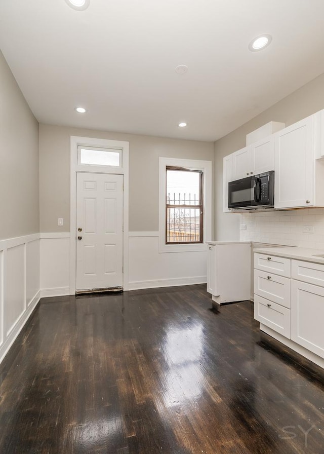 3651 W Grenshaw St, Chicago, IL 60624 - kitchen with black microwave, dark wood-type flooring, wainscoting, white cabinetry, and light countertops