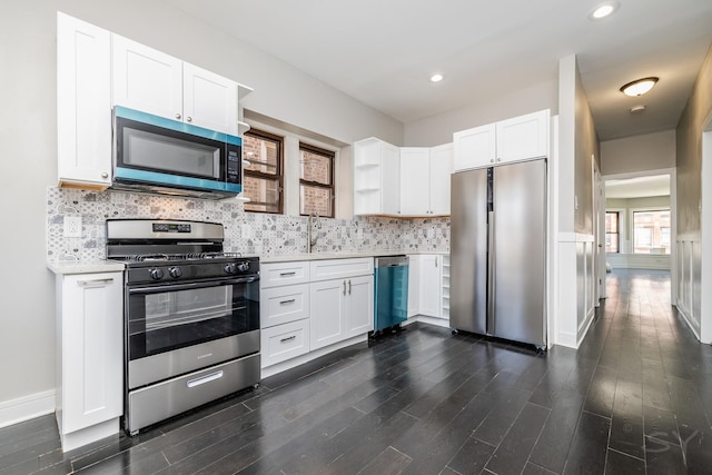 3651 W Grenshaw St, Chicago, IL 60624 - kitchen with appliances with stainless steel finishes, light countertops, open shelves, dark wood-type flooring, and recessed lighting