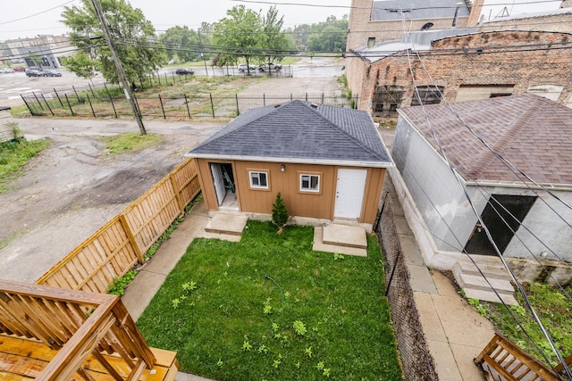 3651 W Grenshaw St, Chicago, IL 60624 - back of property with a fenced backyard, an outbuilding, and a shingled roof