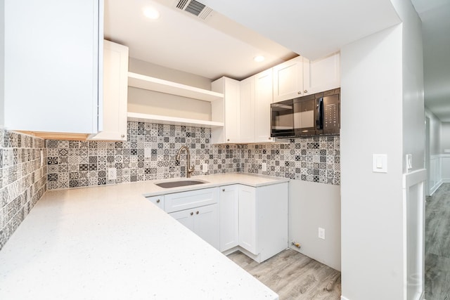 3651 W Grenshaw St, Chicago, IL 60624 - kitchen featuring black microwave, open shelves, white cabinets, light wood-style flooring, and recessed lighting