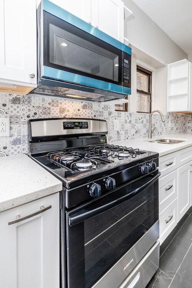 3651 W Grenshaw St, Chicago, IL 60624 - kitchen featuring appliances with stainless steel finishes, white cabinets, decorative backsplash, light stone countertops, and open shelves