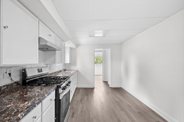 37714 N Nippersink Pl, Spring Grove, IL 60081 - kitchen with stainless steel gas stove, under cabinet range hood, a paneled ceiling, white cabinets, and light wood-style flooring