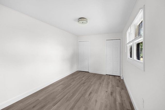 37714 N Nippersink Pl, Spring Grove, IL 60081 - unfurnished bedroom with wood finished floors, multiple closets, and baseboards