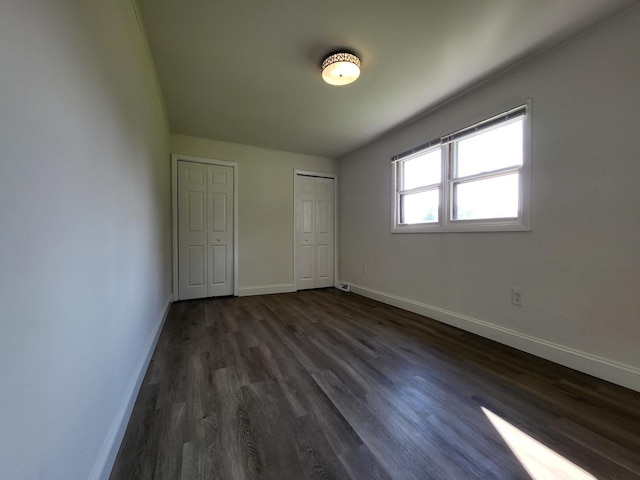 37714 N Nippersink Pl, Spring Grove, IL 60081 - unfurnished bedroom with baseboards, dark wood-style flooring, and two closets