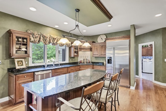 2559 Bird Ln, Batavia, IL 60510 - kitchen featuring appliances with stainless steel finishes, a breakfast bar, light wood finished floors, brown cabinetry, and open shelves
