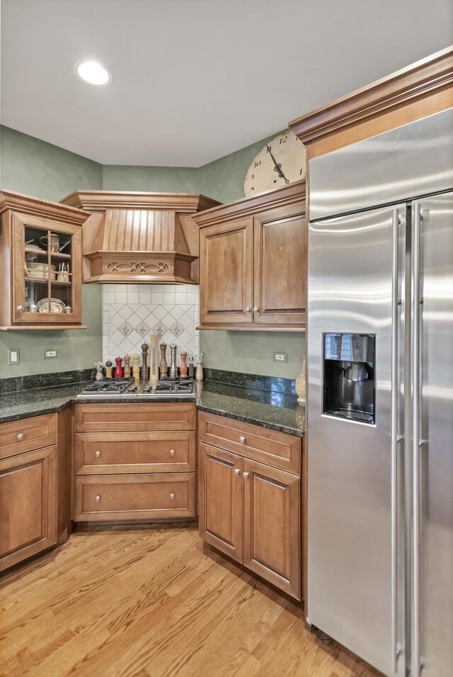 2559 Bird Ln, Batavia, IL 60510 - kitchen featuring stainless steel appliances, wall chimney range hood, light wood-style flooring, glass insert cabinets, and backsplash