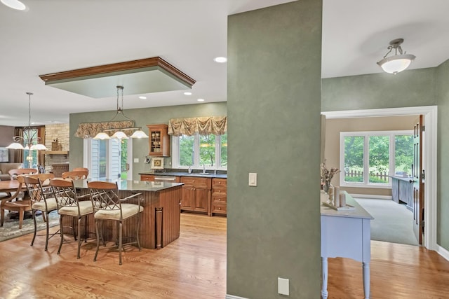 2559 Bird Ln, Batavia, IL 60510 - kitchen with a breakfast bar area, dark countertops, light wood-type flooring, and brown cabinetry