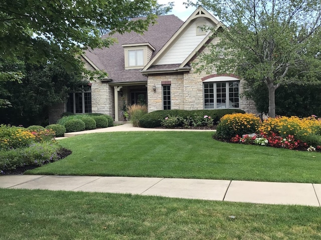 2559 Bird Ln, Batavia, IL 60510 - view of front of house with stone siding, a shingled roof, and a front yard