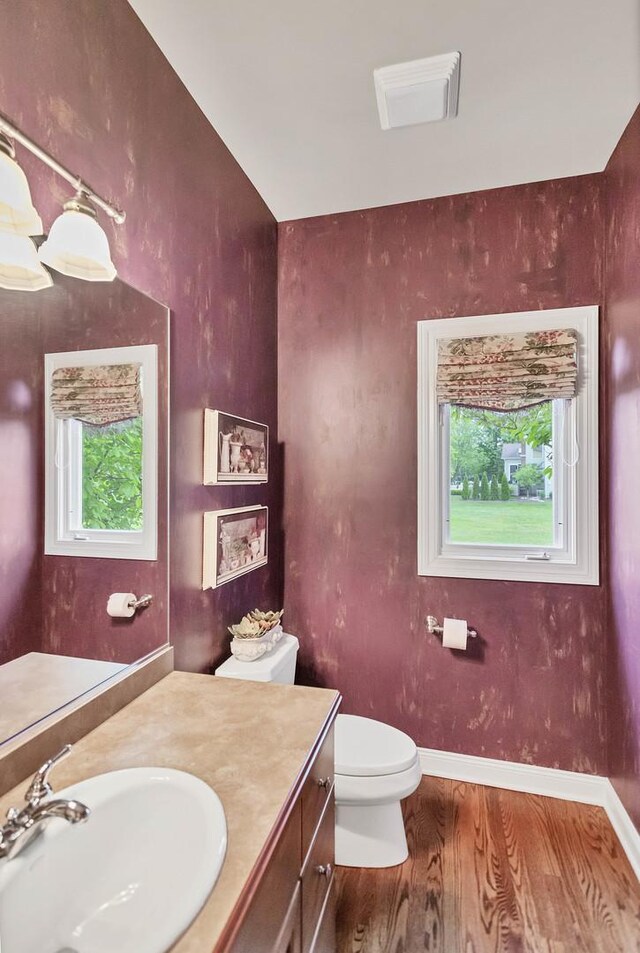 2559 Bird Ln, Batavia, IL 60510 - half bathroom with wood finished floors, toilet, vanity, and baseboards