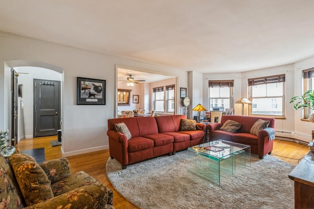 5555 N Sheridan Rd Unit 309, Chicago, IL 60640 - living area featuring arched walkways, baseboard heating, wood finished floors, baseboards, and a ceiling fan