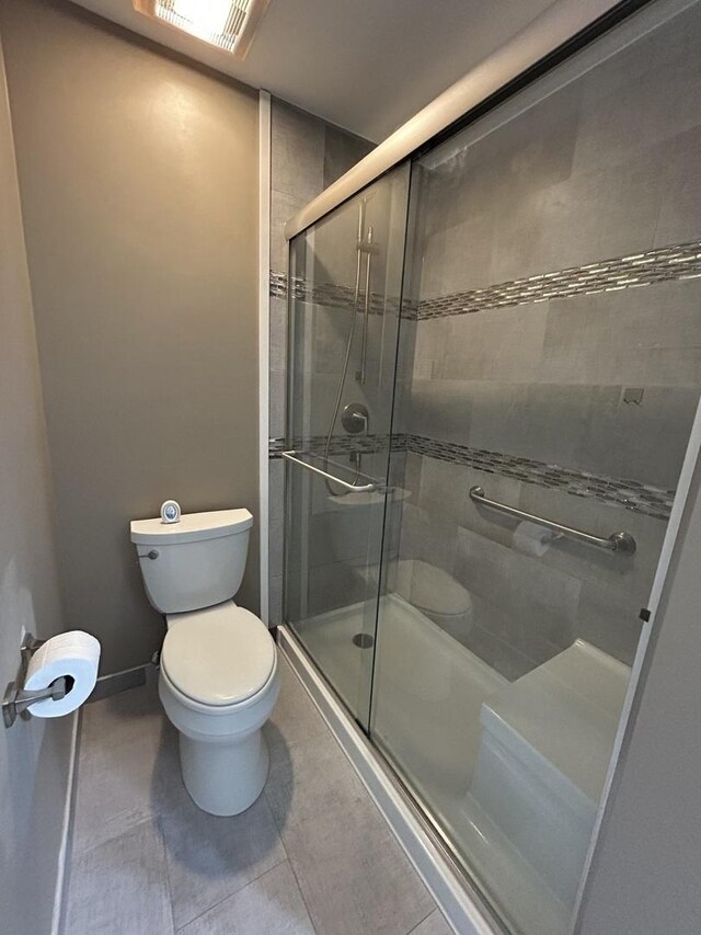 1778 Gloucester Ct Unit B, Wheaton, IL 60189 - bathroom featuring toilet, tiled shower, tile patterned floors, and baseboards