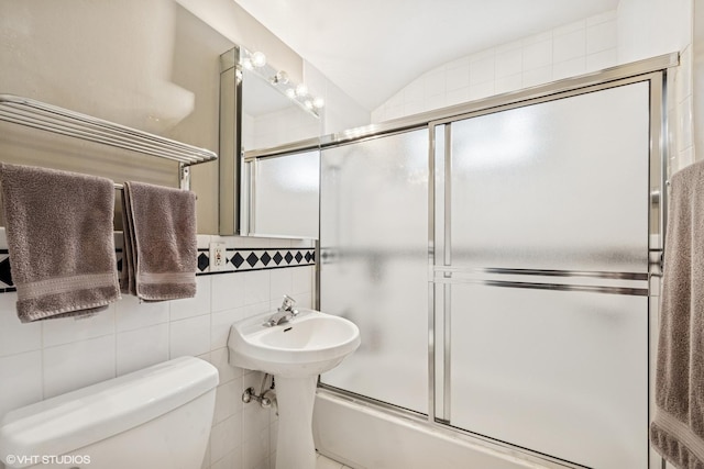 218 S Owen St, Mount Prospect, IL 60056 - bathroom featuring combined bath / shower with glass door, decorative backsplash, lofted ceiling, and tile walls