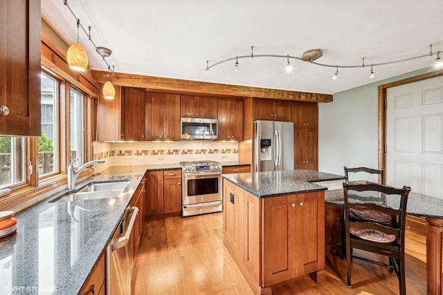 218 S Owen St, Mount Prospect, IL 60056 - kitchen featuring appliances with stainless steel finishes, light wood-style flooring, a kitchen bar, a kitchen island, and decorative backsplash