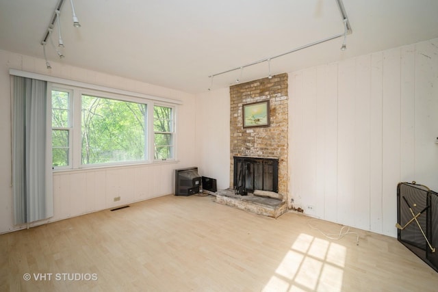 1731 Maple Ave, Northbrook, IL 60062 - unfurnished living room featuring rail lighting, wood finished floors, and a fireplace