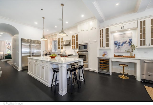 2015 N Howe St, Chicago, IL 60614 - kitchen featuring built in appliances, beverage cooler, under cabinet range hood, a kitchen bar, and white cabinets