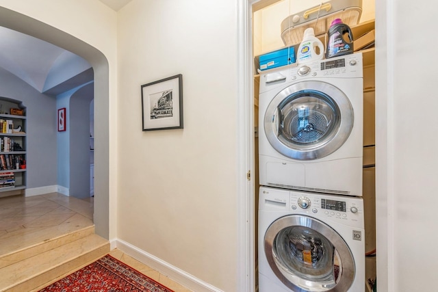 421 W Melrose St Unit 10B, Chicago, IL 60657 - washroom featuring estacked washer and dryer, arched walkways, baseboards, and tile patterned floors
