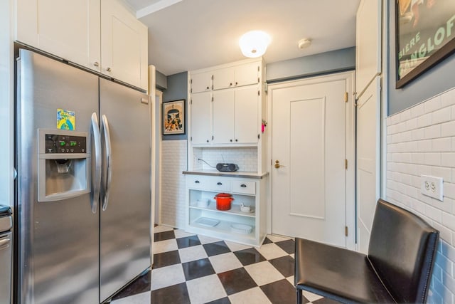 421 W Melrose St Unit 10B, Chicago, IL 60657 - kitchen featuring stainless steel fridge with ice dispenser, white cabinets, tile patterned floors, and backsplash